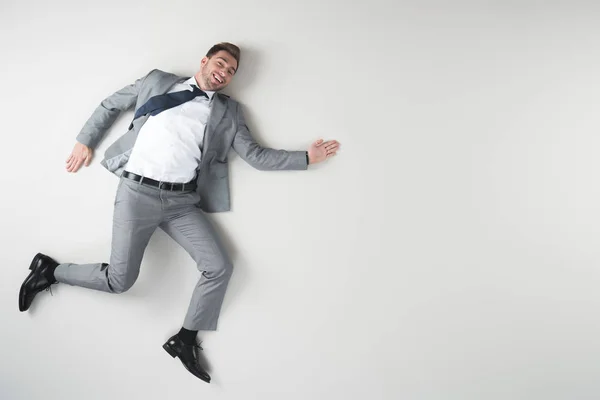 Vista aérea del hombre de negocios sonriente en traje aislado en gris - foto de stock