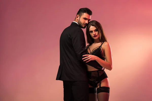 Giovane uomo d'affari che abbraccia con bella ragazza in lingerie — Foto stock