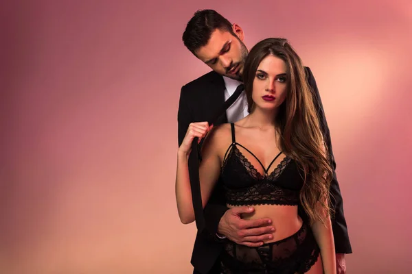 Beau homme d'affaires câlin avec fille sexy en lingerie — Photo de stock