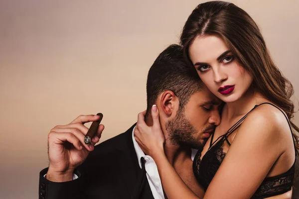 Handsome businessman with cigar kissing beautiful girl in lingerie — Stock Photo