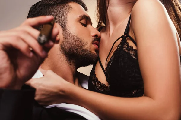 Schöner Geschäftsmann mit Zigarre küsst schönes Mädchen in Dessous — Stockfoto