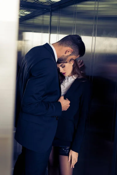 Sensual attractive business couple in elevator — Stock Photo