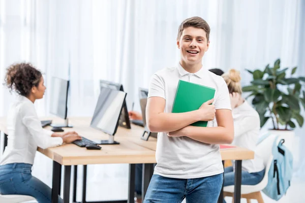 Joven feliz caucásico estudiante chico en aula con amigos - foto de stock