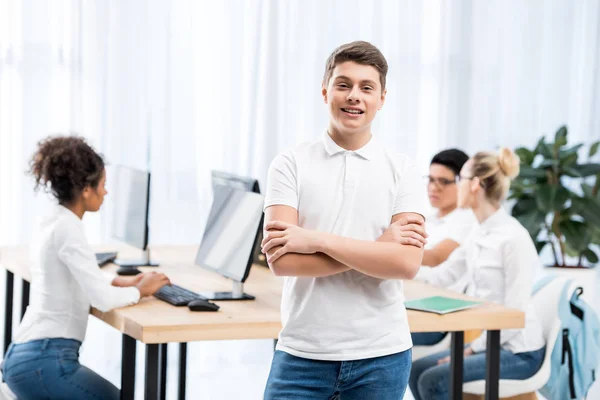 Jovem menino estudante caucasiano feliz em sala de aula com amigos — Fotografia de Stock