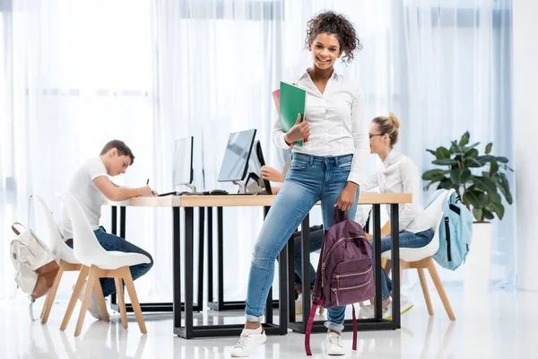 Joven afroamericana estudiante chica en el aula con amigos — Stock Photo