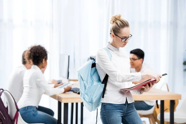 Young pensive caucasian student girl in classroom with friends — Stock Photo