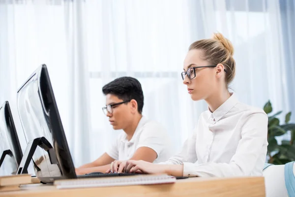 Young teenager students studying on computers — Stock Photo