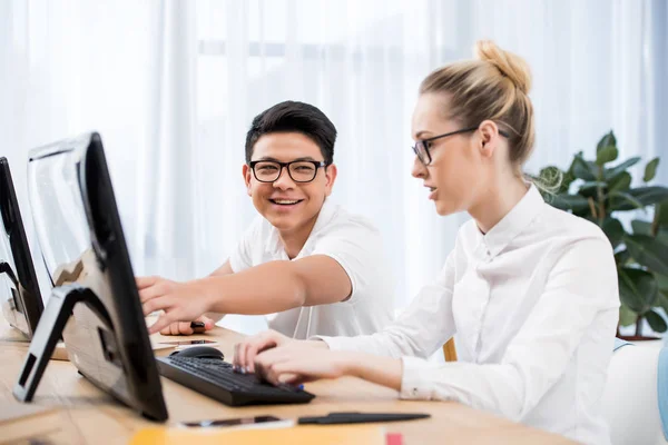 Jovens estudantes felizes apontando na tela do computador — Fotografia de Stock