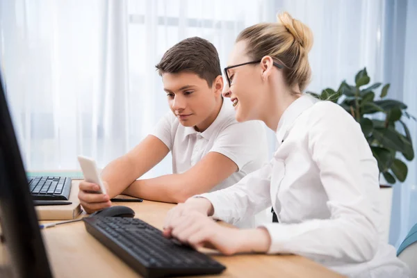 Jóvenes estudiantes adolescentes mirando el teléfono inteligente - foto de stock