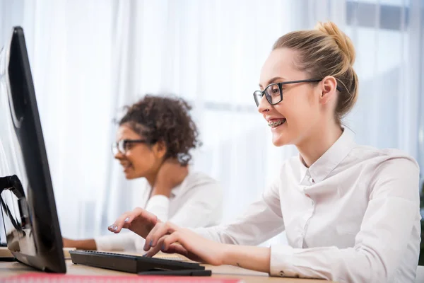 Young attractive teenager girls studying on computers — Stock Photo