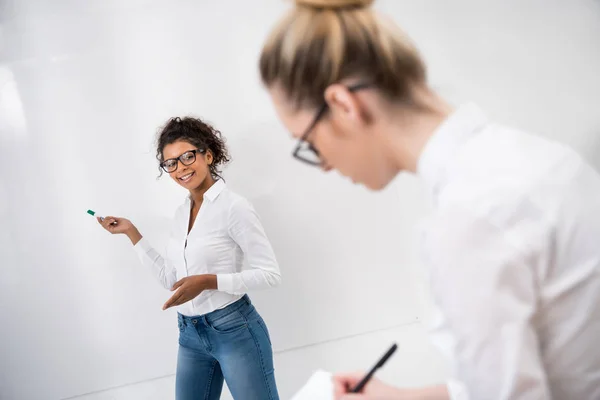Young african american student pointing on white board — Stock Photo