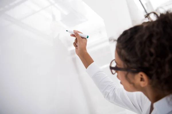 Jeune adolescent afro-américain écrivant sur un tableau blanc — Photo de stock