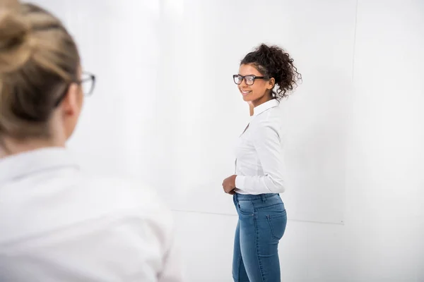 Young african american teenager writing on white board — Stock Photo