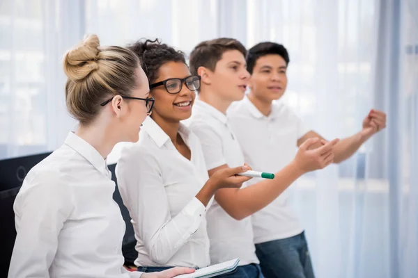 Jeunes étudiants multiculturels regardant et pointant du doigt quelque chose — Photo de stock