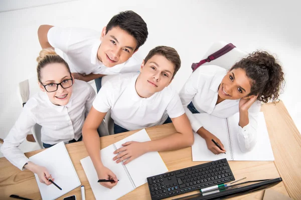 Young students writing something in notebooks — Stock Photo
