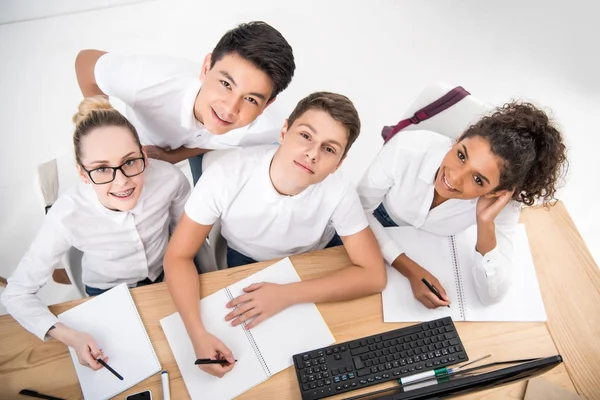 Junge Studenten schreiben etwas in Notizbücher — Stockfoto