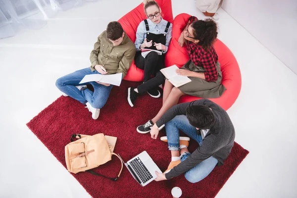 Adolescentes multiculturais estudando com laptop e cadernos — Fotografia de Stock