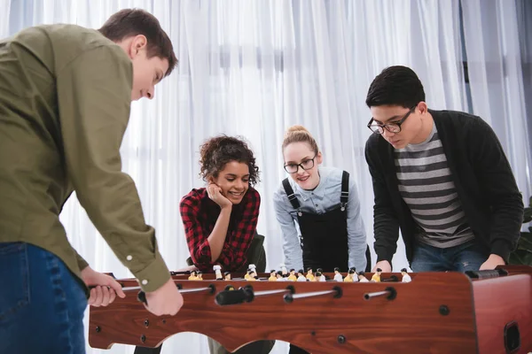 Happy young teenagers playing in table soccer — Stock Photo