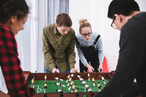 Happy cheerful teenagers playing in table soccer — Stock Photo