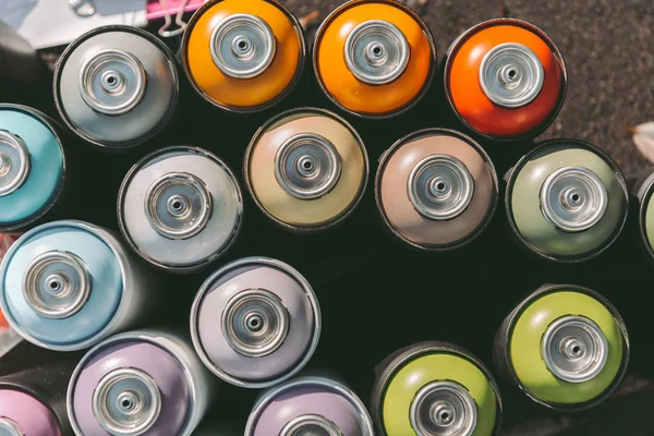 Top view of cans with colorful spray paint for graffiti on asphalt — Stock Photo