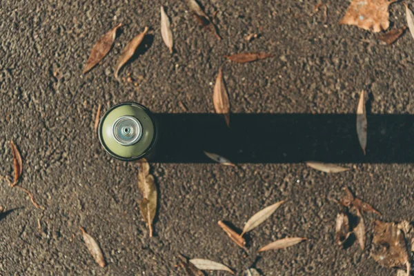 Vista superior de lata con pintura en aerosol sobre asfalto con sombra - foto de stock
