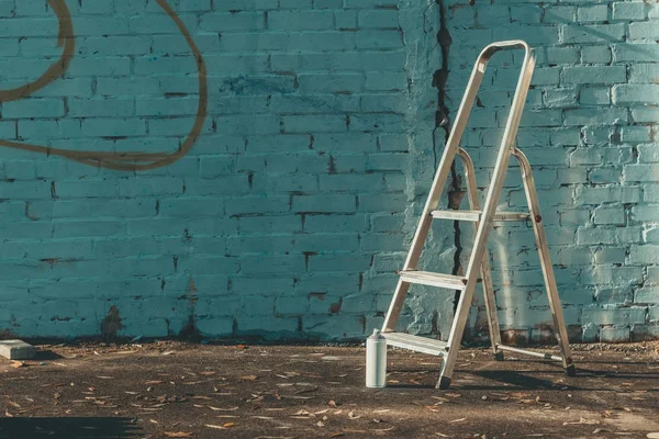 Ladder and can with colorful spray paint near wall — Stock Photo