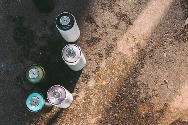 Top view of aerosol paint for graffiti on asphalt — Stock Photo