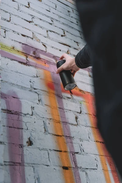 Cropped view of street artist painting colorful graffiti on wall of building — Stock Photo
