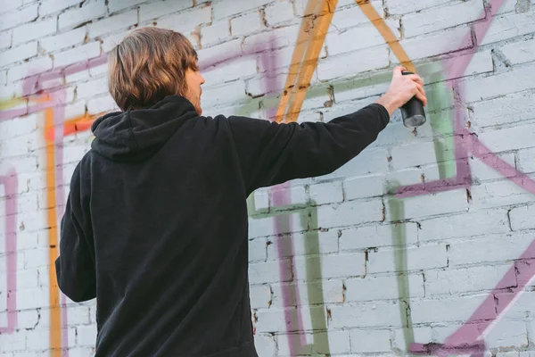 Street artist painting colorful graffiti on wall of building — Stock Photo