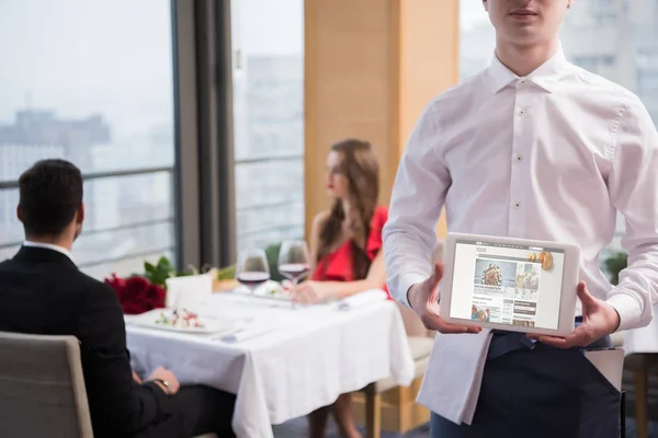 Selective focus of waiter showing tablet in hands in restaurant — Stock Photo