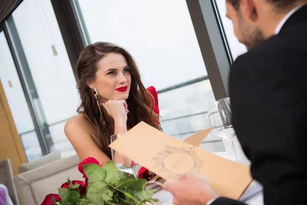 Mujer sonriente mirando novio durante San Valentín fecha en el restaurante - foto de stock