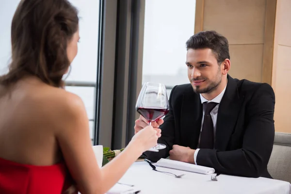Частковий вид пари клінкерних келихів червоного вина під час романтичного побачення в ресторані на день святого Валентина — стокове фото