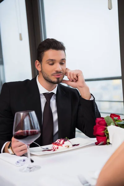 Vista parcial del hombre en traje sentado en la mesa en la cita romántica con la novia en el restaurante, día de San Valentín - foto de stock