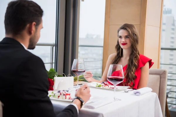 Vista parcial de pareja enamorada teniendo cita romántica en restaurante el día de San Valentín - foto de stock