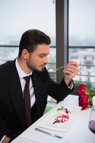 Вид сбоку на человека, который ест десерт в ресторане — стоковое фото