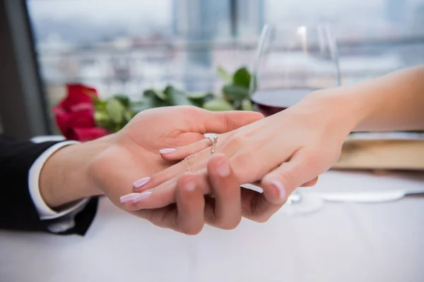 Cropped shot of boyfriend holding fiances hand during romantic date in restaurant — Stock Photo