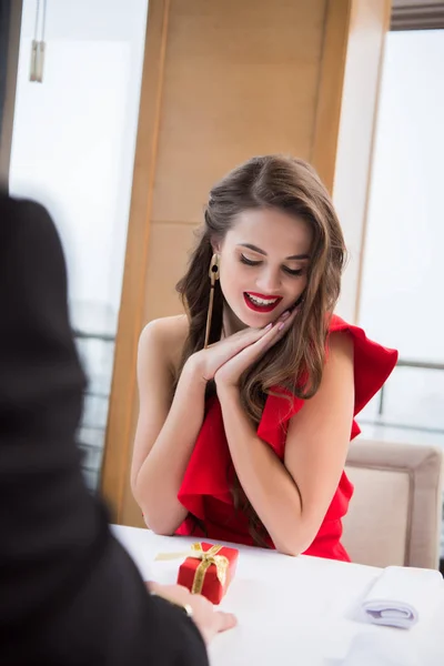 Partial view of man presenting gift to girlfriend in restaurant on st valentine day — Stock Photo