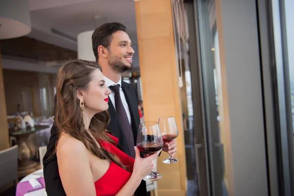 Пара в келихах червоного вина святкує день святого Валентина в ресторані — стокове фото