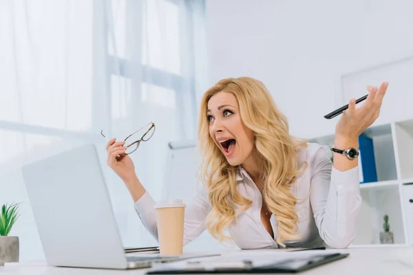 Mujer de negocios gritando mientras trabaja con el ordenador portátil - foto de stock
