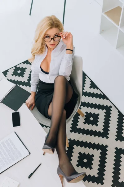 Overhead view of sexy woman sitting in chair and looking at camera — Stock Photo