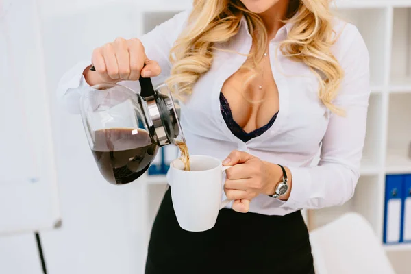 Imagen recortada de mujer seductora vertiendo café en taza - foto de stock