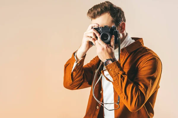 Visão obscurecida do homem da moda tirar foto na câmera fotográfica isolada no bege — Fotografia de Stock