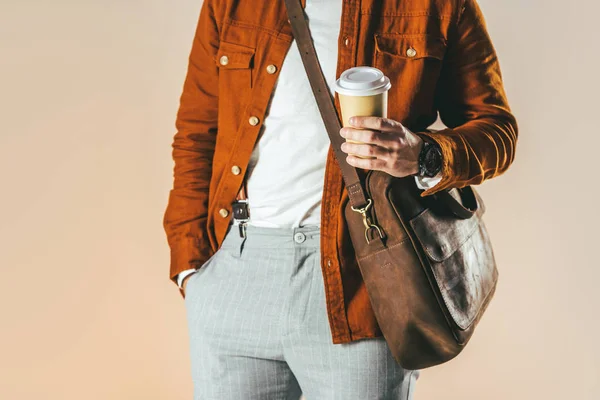 Partial view of man in stylish clothing holding coffee to go isolated on beige — Stock Photo