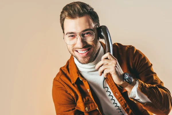 Retrato de hombre alegre hablando por teléfono aislado en beige - foto de stock
