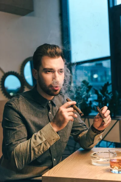 Portrait of handsome man smoking cigar in cafe — Stock Photo