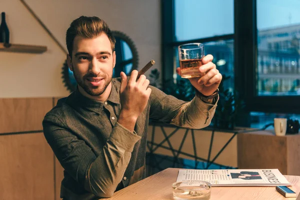 Portrait d'homme d'affaires avec cigare tenant verre de cognac dans un café — Photo de stock