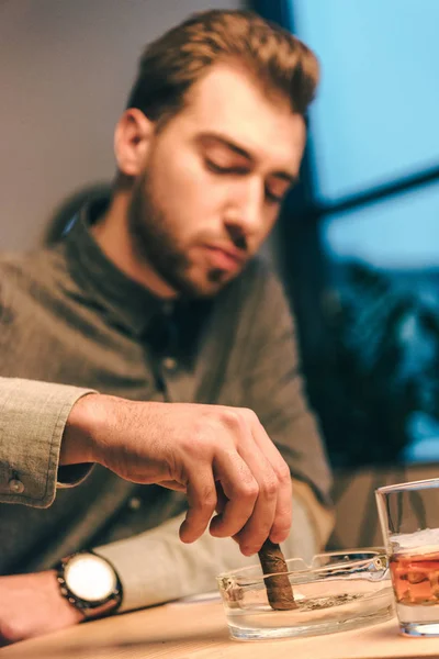 Selective focus of man putting out cigar in ashtray in cafe — Stock Photo