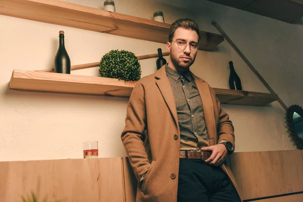 Портрет серйозного чоловіка в куртці зі склянкою віскі біля кафе — стокове фото
