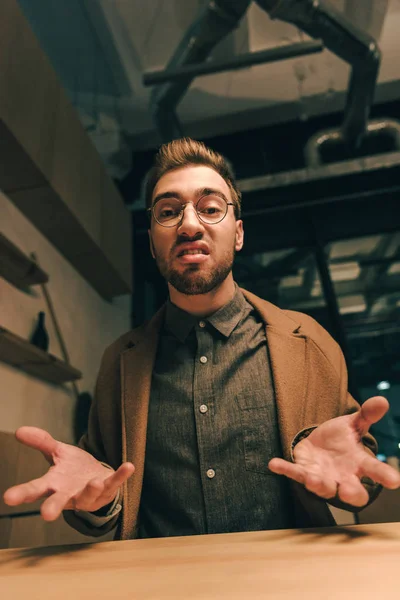 Portrait d'un tyran gesticulant et regardant une caméra dans un café — Photo de stock