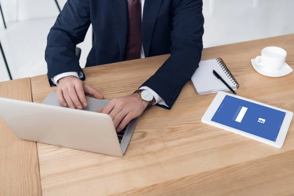 Vista parziale di uomo d'affari che lavora su computer portatile a posto di lavoro con targa in ufficio — Foto stock